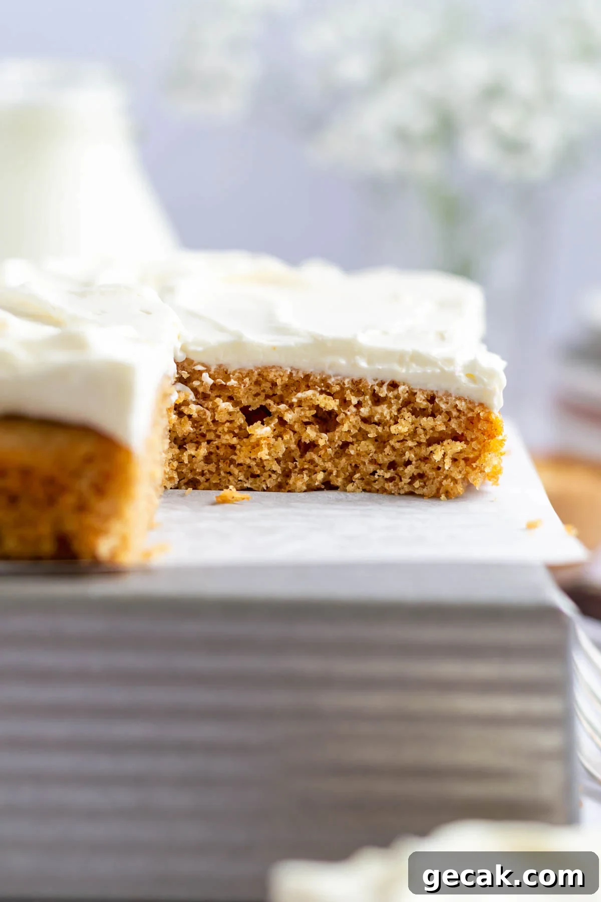 No-Bake Graham Cracker Cake Recipe: Layered Dessert with Creamy Filling 3 graham cracker cake slice sitting on parchment lined cake tin