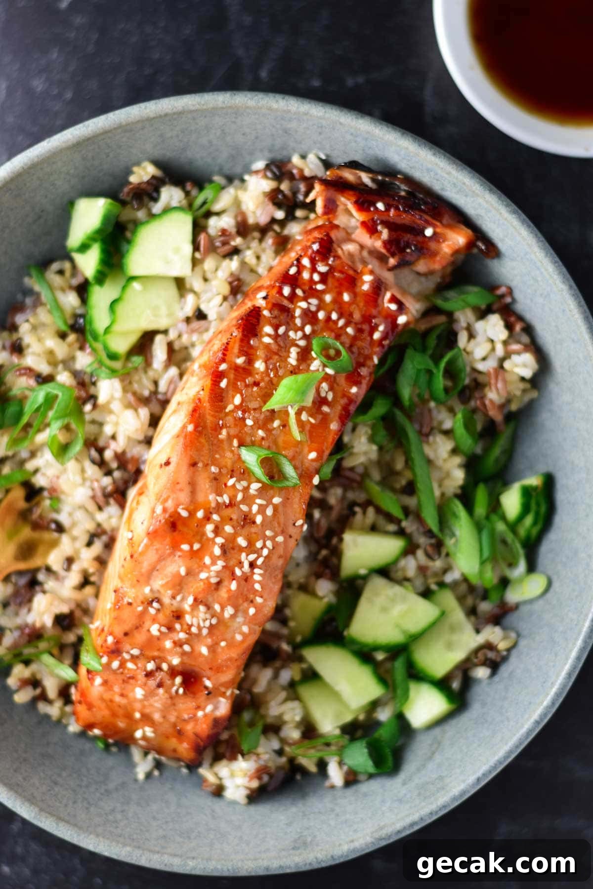 Sweet chili salmon on a bed of rice topped with sesame seeds.