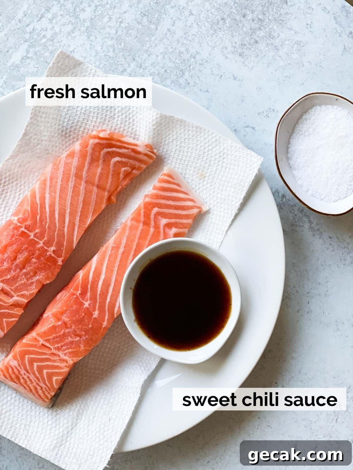 Salmon next to sweet chili sauce.