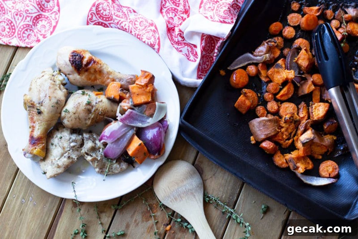 White plate with oven baked chicken, side of carrots, sweet potatoes, and red onions.
