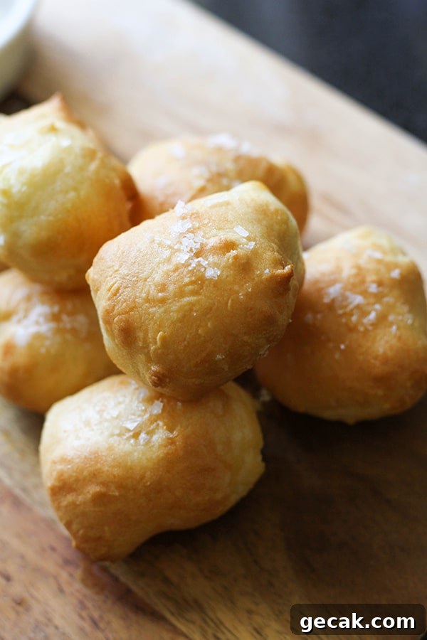 pretzel bites stacked on a wooden serving board.
