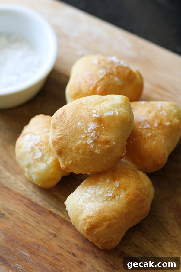 pretzel bites stacked on a wooden serving board.