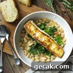 Have dinner in a bowl with pan seared halibut over creamy white beans and sauteed spinach!