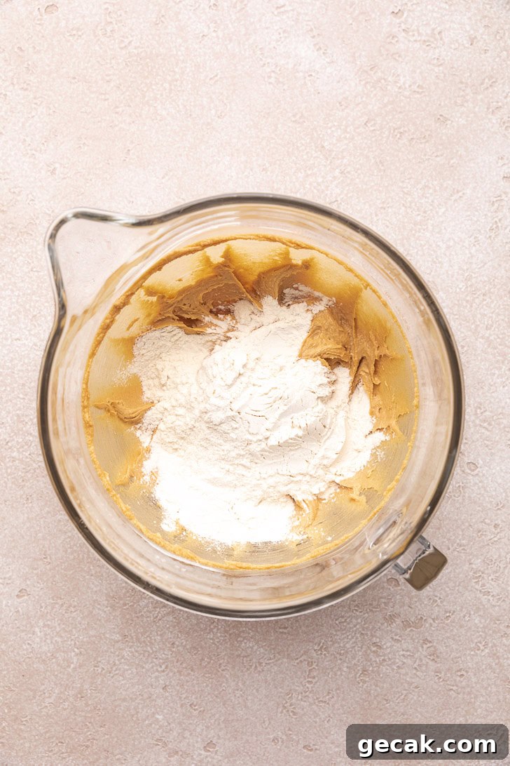 Flour mixture poured into a bowl of wet ingredients.