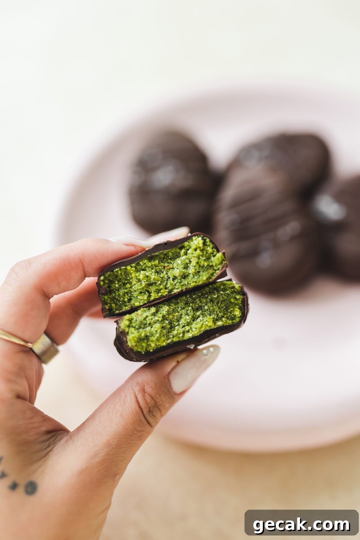 a hand holding two pieces of chocolate peanut butter vegan easter eggs