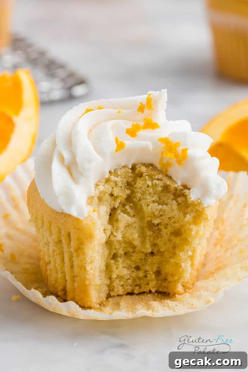 Gluten-Free Orange Cupcakes Recipe with Zesty Citrus Frosting 6 gluten free orange cupcake with a bite out of it