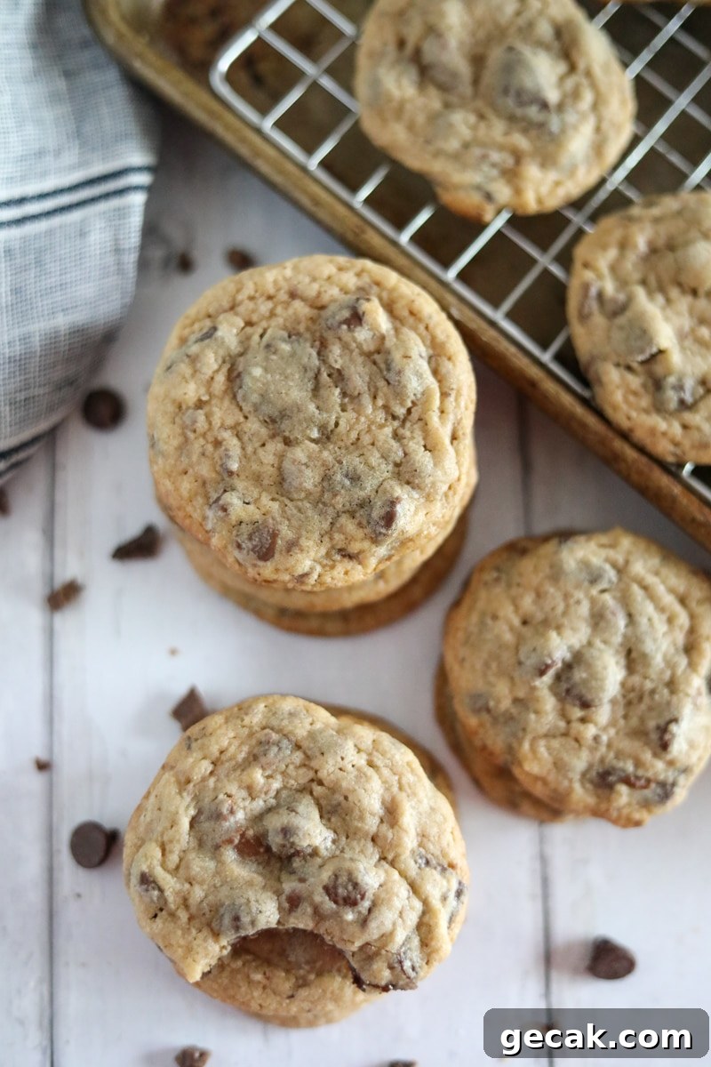 three stacks of chocolate chip cookies with a sheet pan in the background