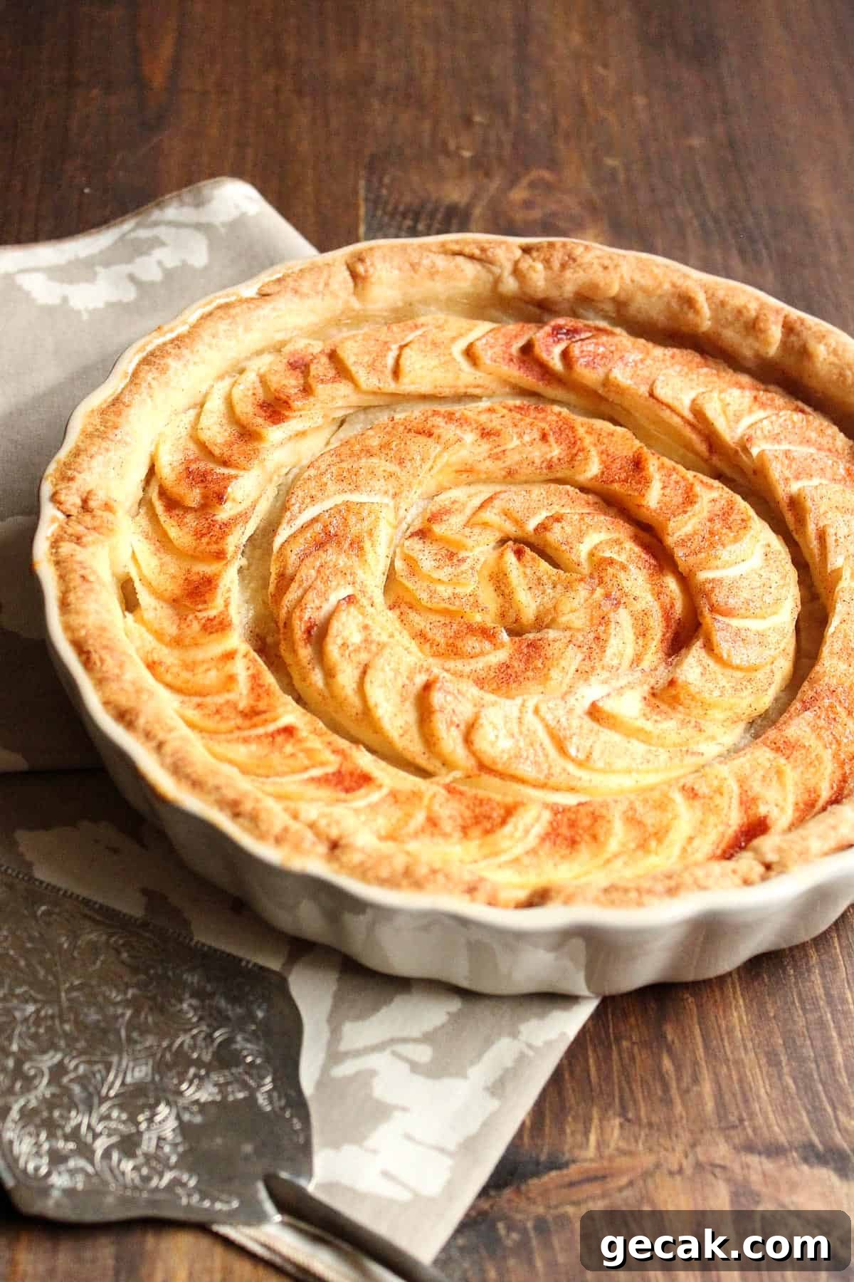 Apple pie tart with almond paste filling with a pie server to the side.