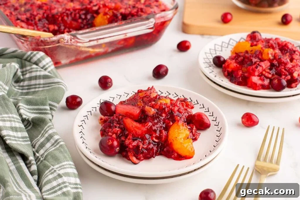 Cranberry jello salad casserole on two plates with a fork.