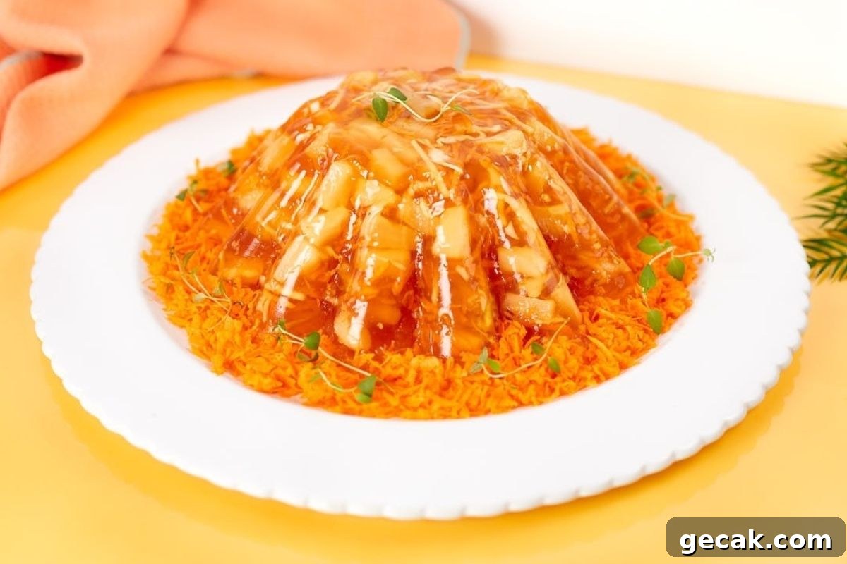 A plate with a dish of orange jello salads on it.