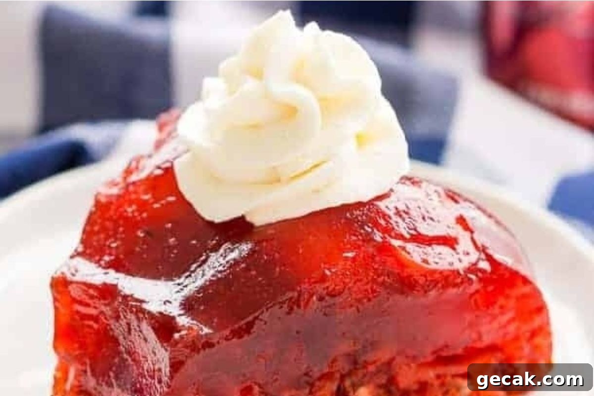 A slice of strawberry rhubarb pie on a plate, next to a serving of jello salads.