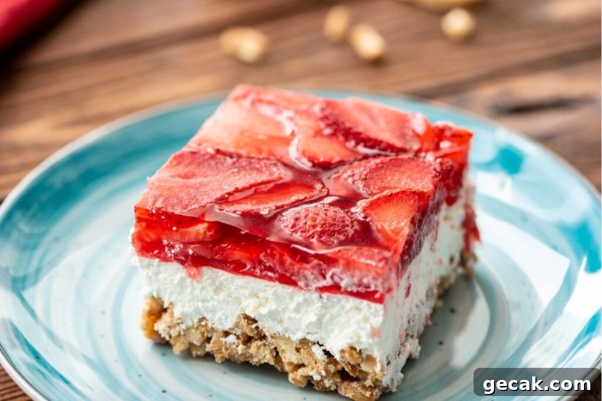 A slice of strawberry cheesecake with jello salads on a plate.