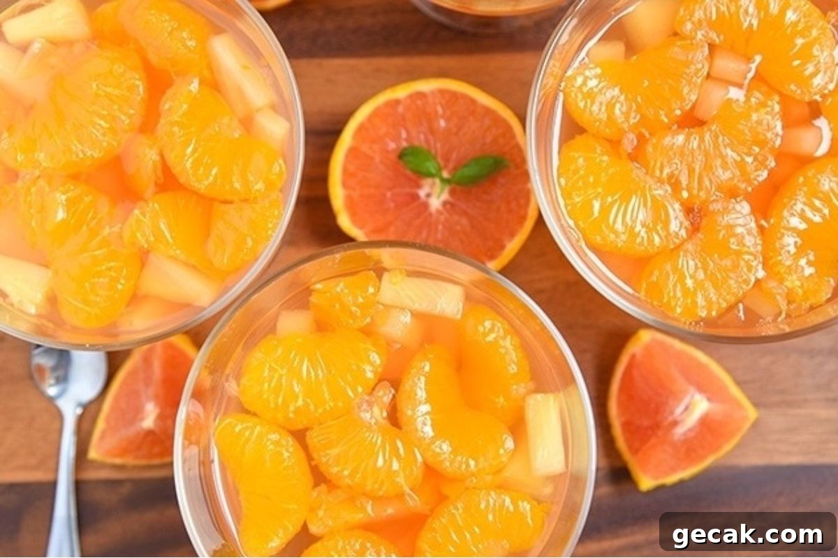 A bowl of orange jello salads with slices of oranges.