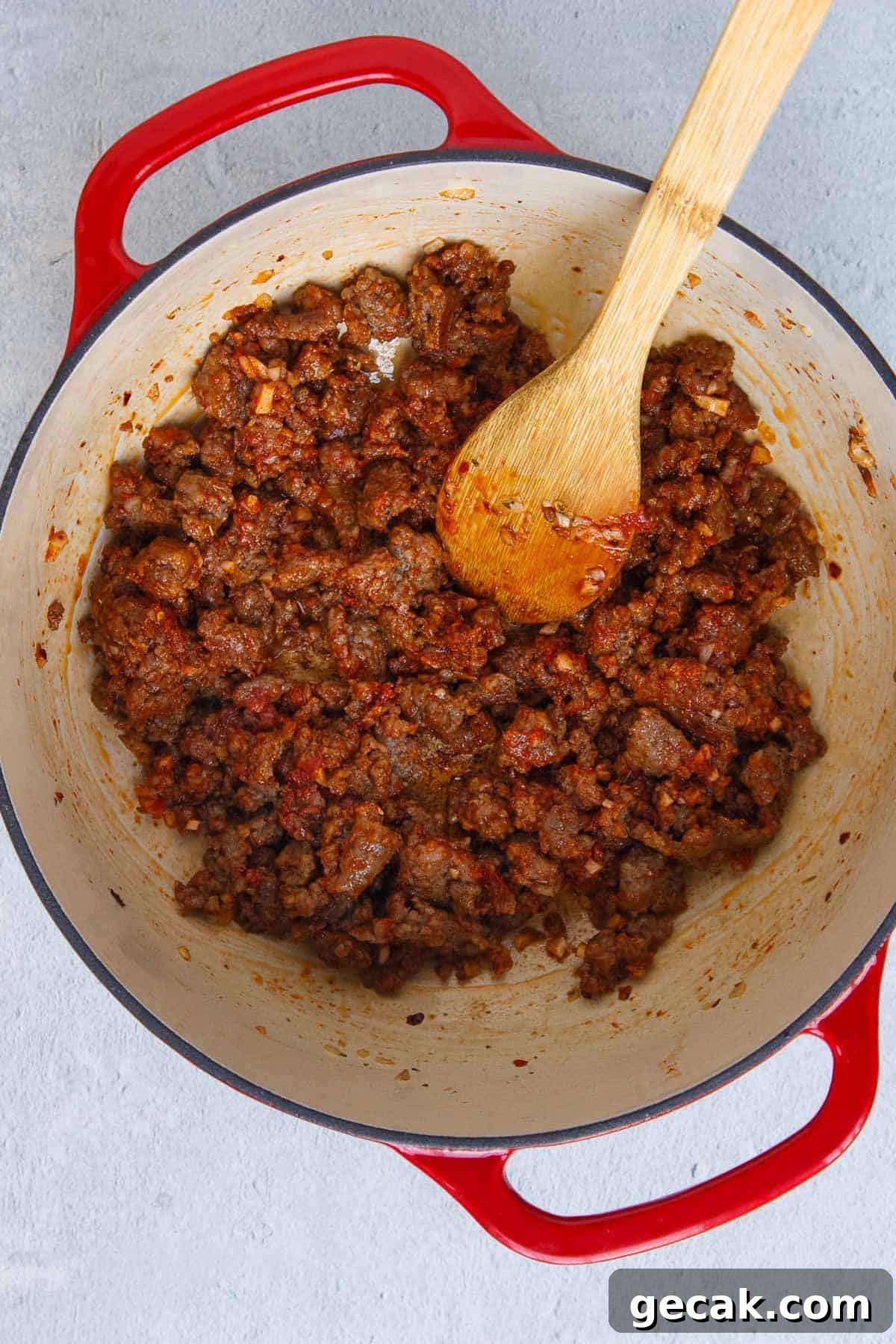 Tomato paste mixed in with cooked Italian sausage