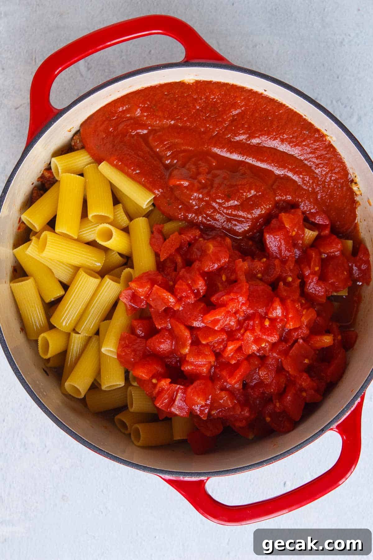 Uncooked rigatoni, diced tomatoes, marinara, and chicken broth in a large pot