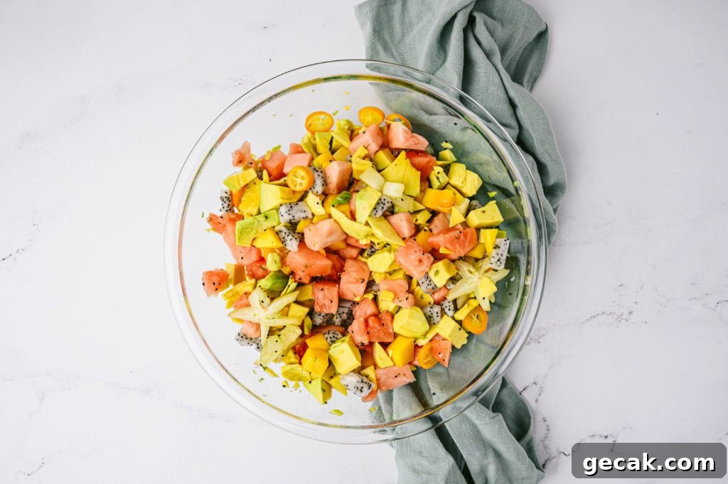 tropical fruit salad mixed together in glass bowl