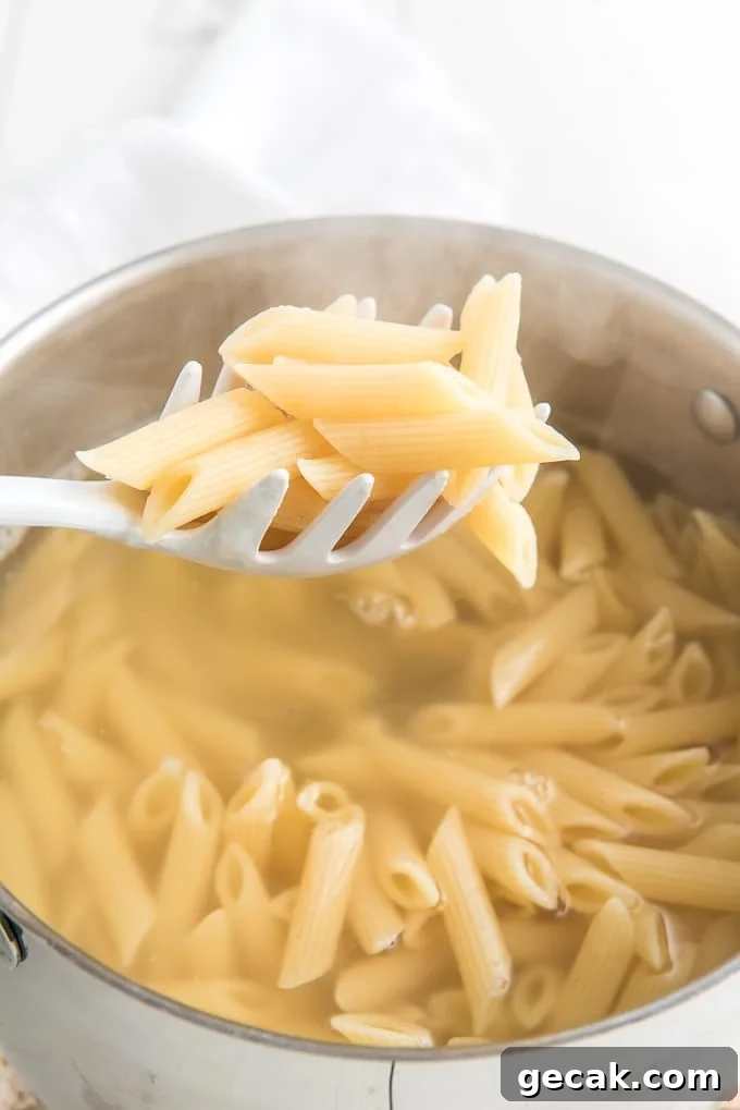 Cheesy Baked Penne Pasta with Crispy Breadcrumb Topping 5 A pot of pasta is cooked.