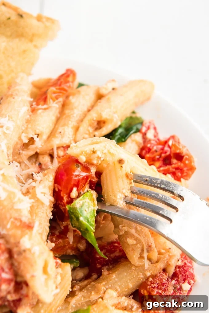 Cheesy Baked Penne Pasta with Crispy Breadcrumb Topping 8 A fork is lifting a piece of pasta from a plate.