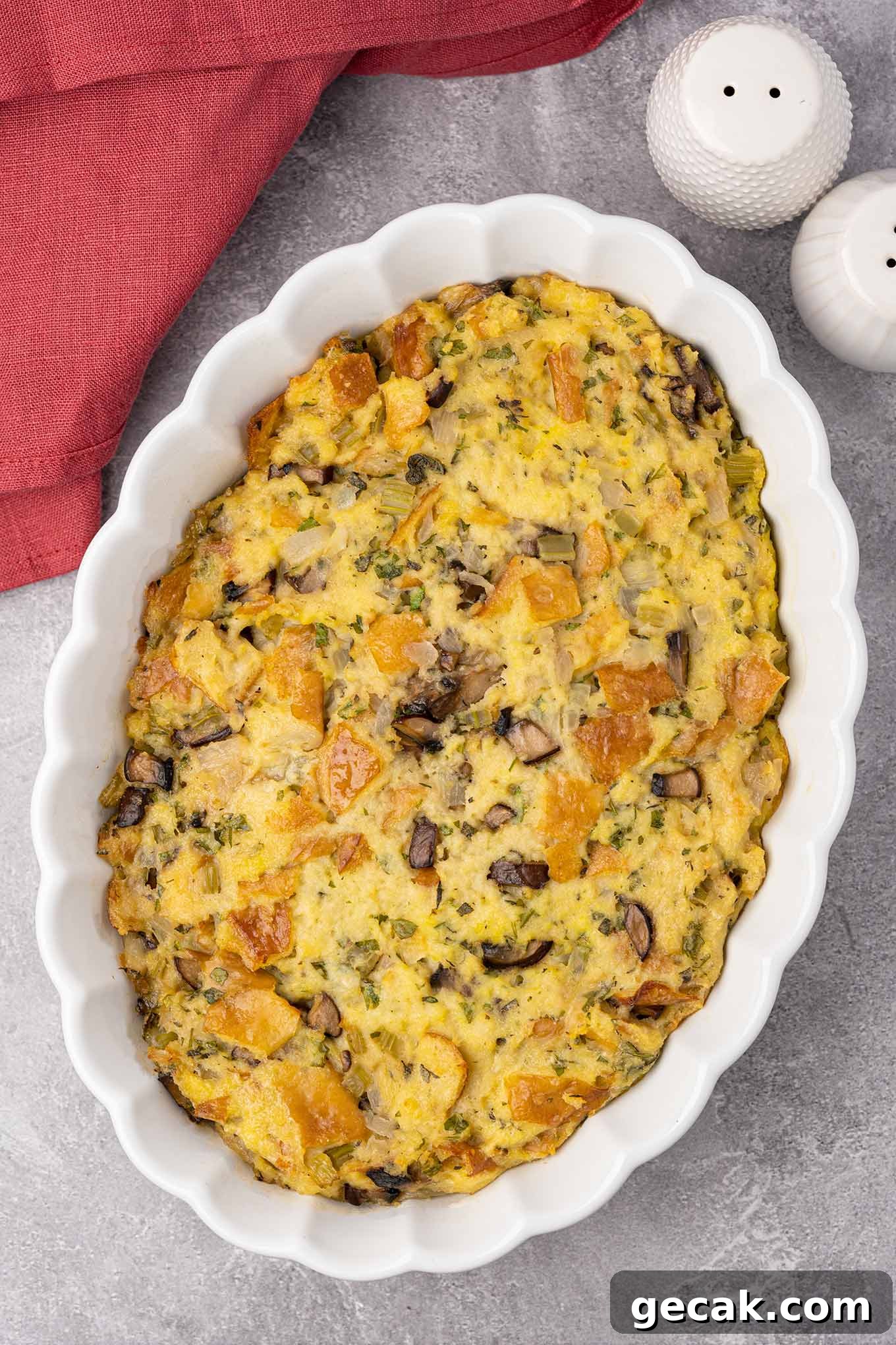 Classic Old-Fashioned Bread Stuffing Recipe for Thanksgiving 2 An oval casserole dish filled with old-fashioned bread stuffing made with sourdough bread, celery, onions, and mushrooms.