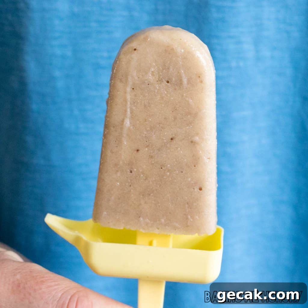 fresh banana pop held in front of blue background