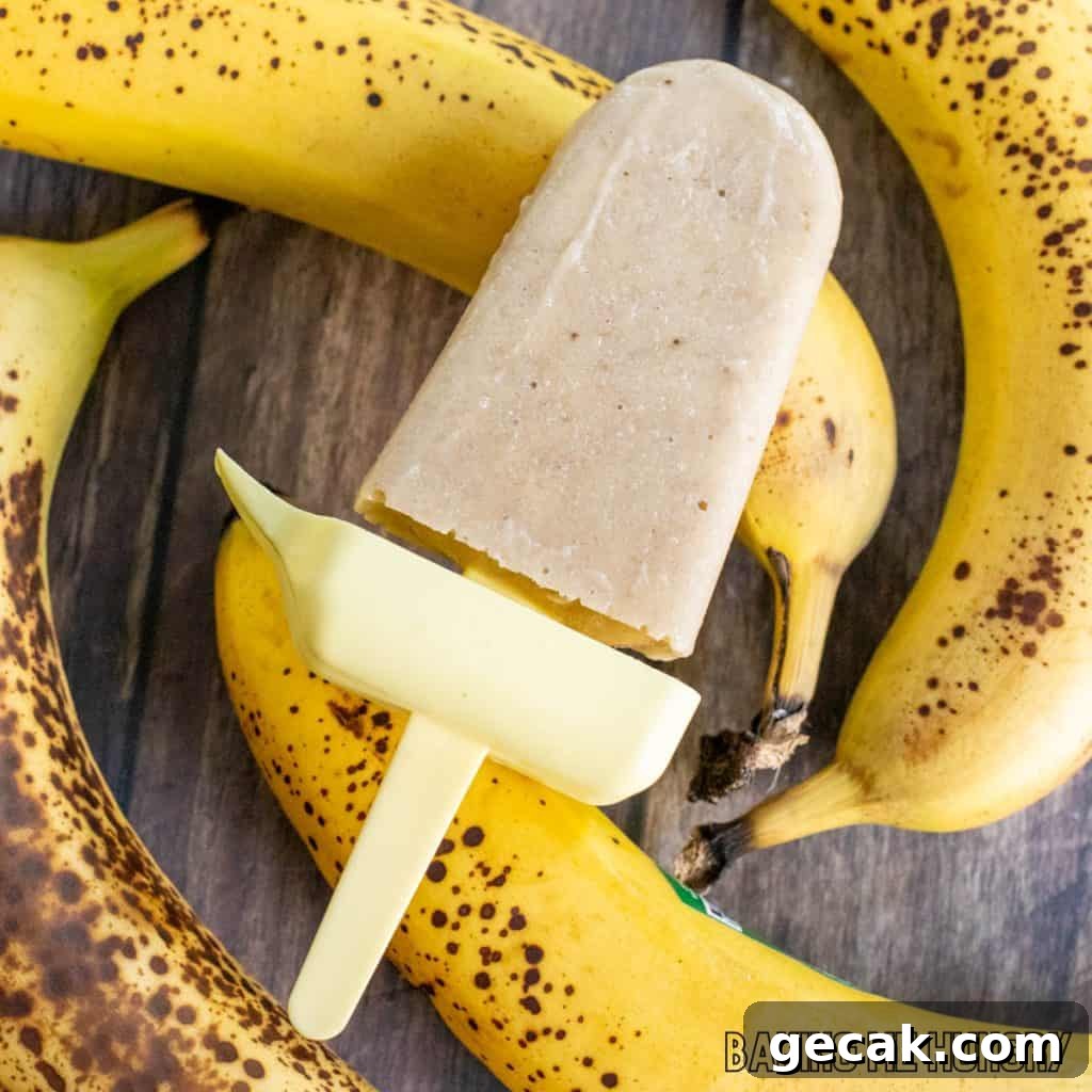 creamy banana popsicle resting on fresh bananas