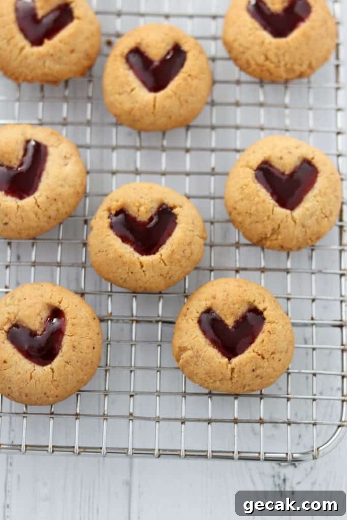 Raspberry Hazelnut Heart Cookies Recipe 7 A close up of raspberry heart cookies on a cooling rack