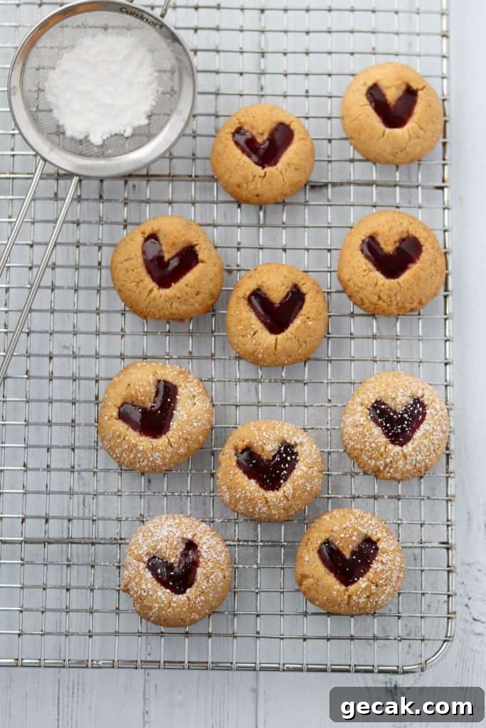 Raspberry Hazelnut Heart Cookies Recipe 8 Raspberry heart cookies on a cooling rack with powdered sugar