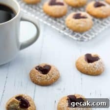 Raspberry heart cookies next to a cup of coffee