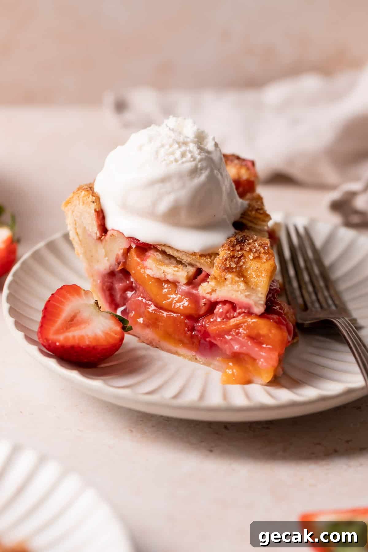 Brown Butter Strawberry and Peach Pie Recipe 5 a slice of pie with a scoop of vanilla ice cream on top.