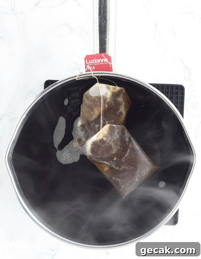 tea bags steeping in a stainless steel pot