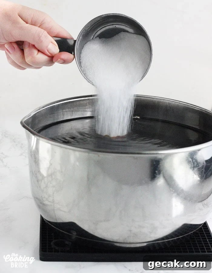 pouring sugar into the pan of steeped tea