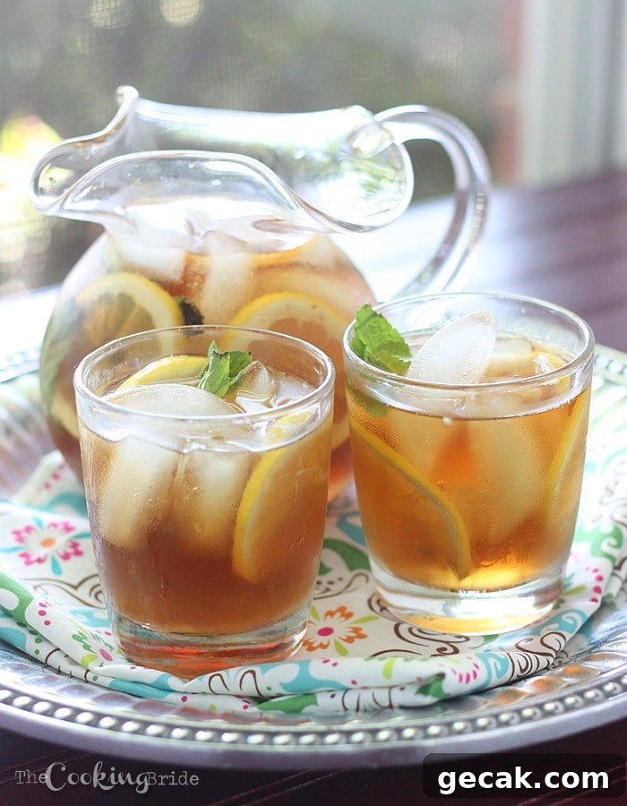 pitcher of sweet tea and two glasses on a pewter serving tray infront of a window