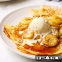 a plate of crepes with banana foster topping and a scoop of vanilla icecream