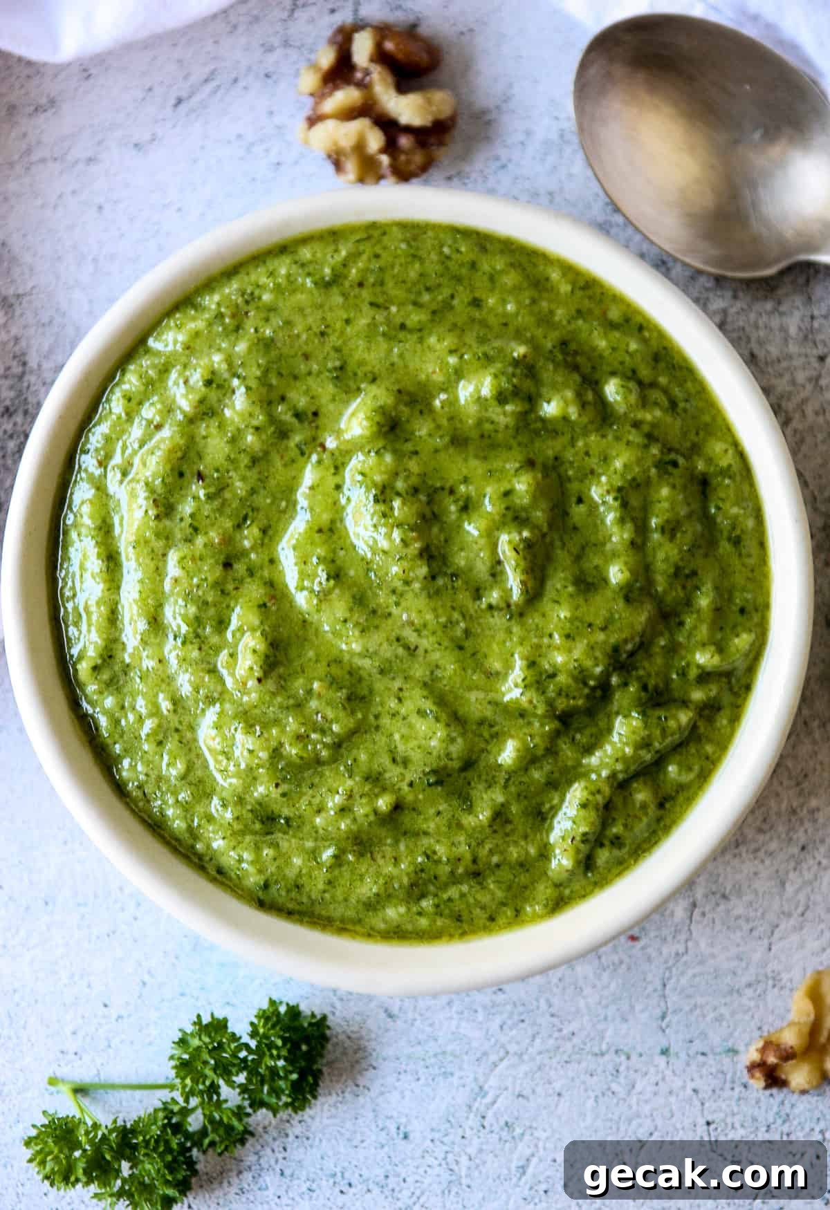 Parsley and Walnut Pesto Recipe: Fresh Homemade Sauce 3 Parsley pesto in a white dish next to a silver spoon.