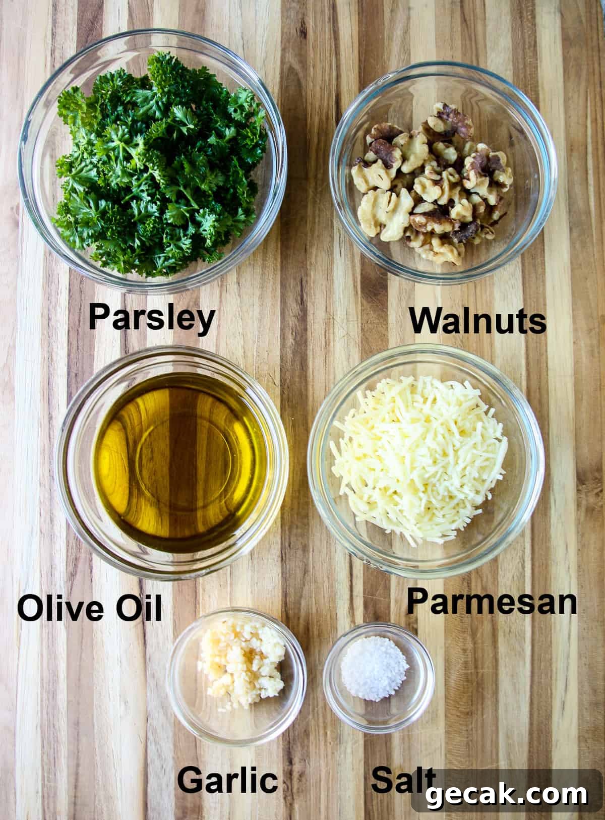 Parsley and Walnut Pesto Recipe: Fresh Homemade Sauce 4 The ingredients required for this recipe in glass bowls on a wooden board.