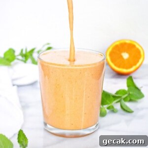 A smoothie being poured into a clear glass.