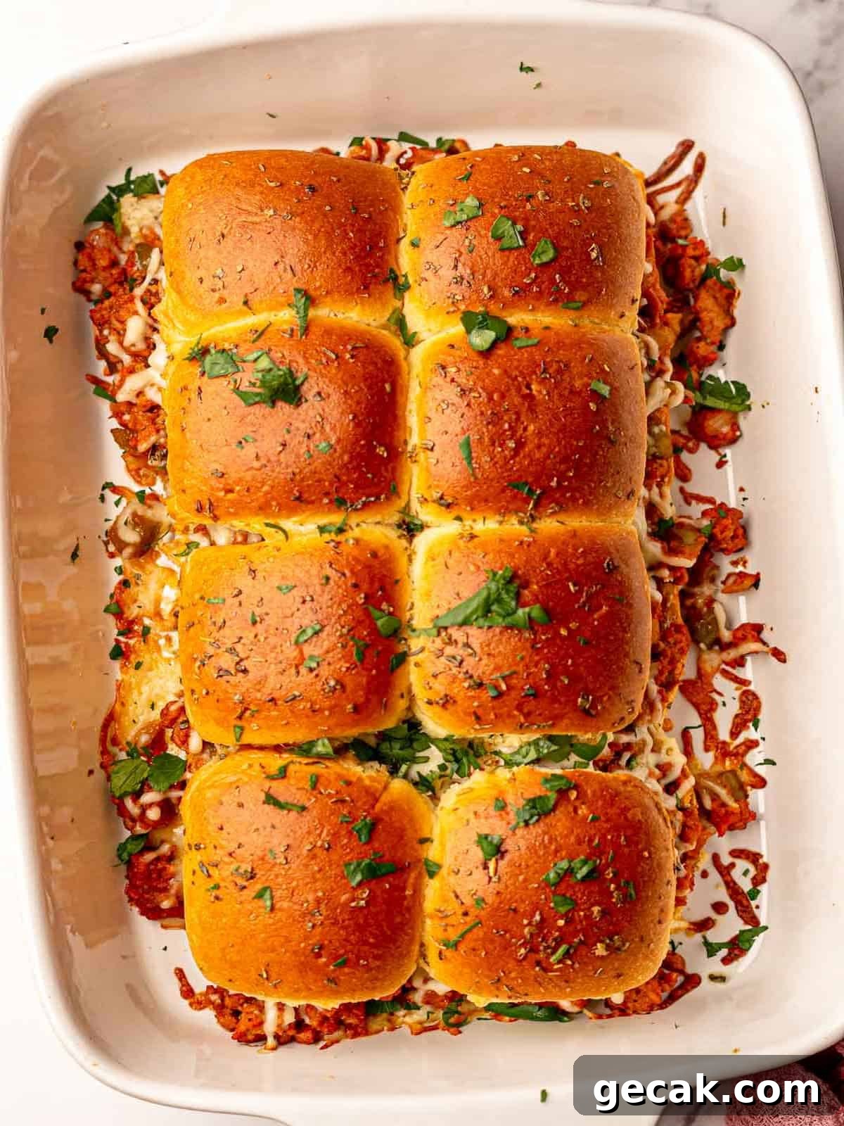 Sloppy joe sliders in a white baking dish.
