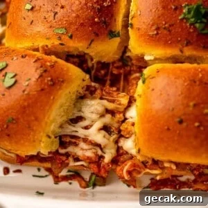 Two sliders with cheese in a baking dish.