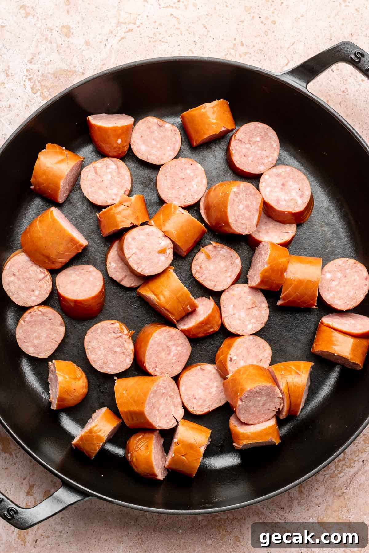 Cut pieces of kielbasa in a frying pan.