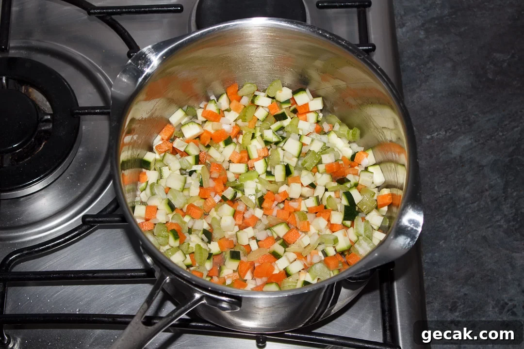 Carrot, courgette, celery and onion frying in a large saucepan