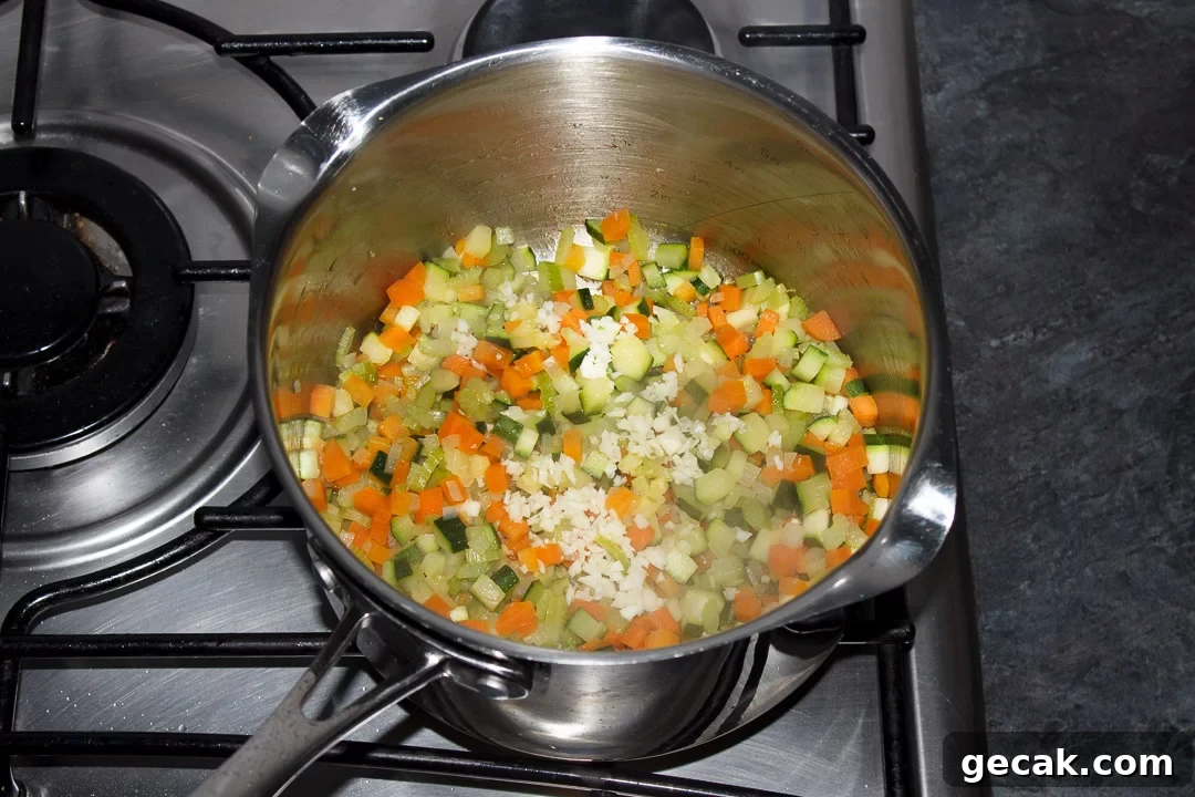 Carrot, courgette, celery, onion and garlic frying in a large saucepan