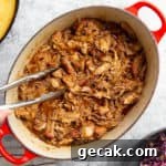 Traeger pulled pork in a pot with tongs.