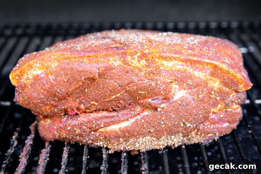 Pork shoulder on a Traeger grill before cooking.