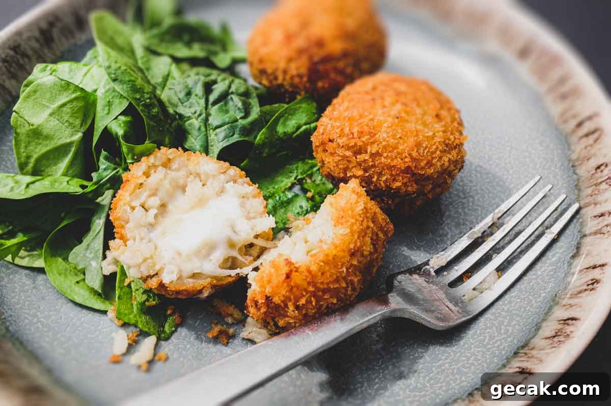 Top 10 Must-Try Recipes from 2020 for Home Cooks 8 Suppli (Italian Rice Balls) on a plate with some fresh spinach leaves