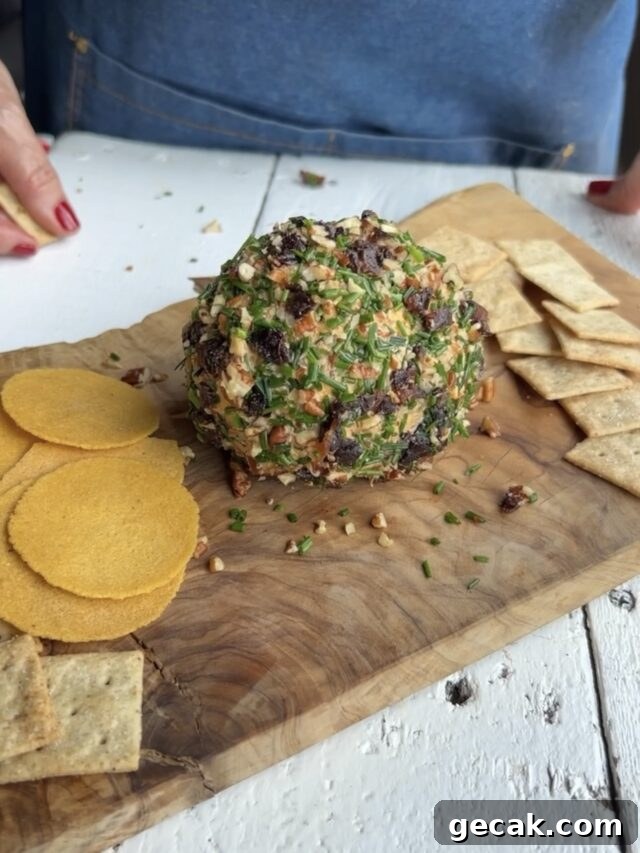 Finished cheeseball on a wood board.
