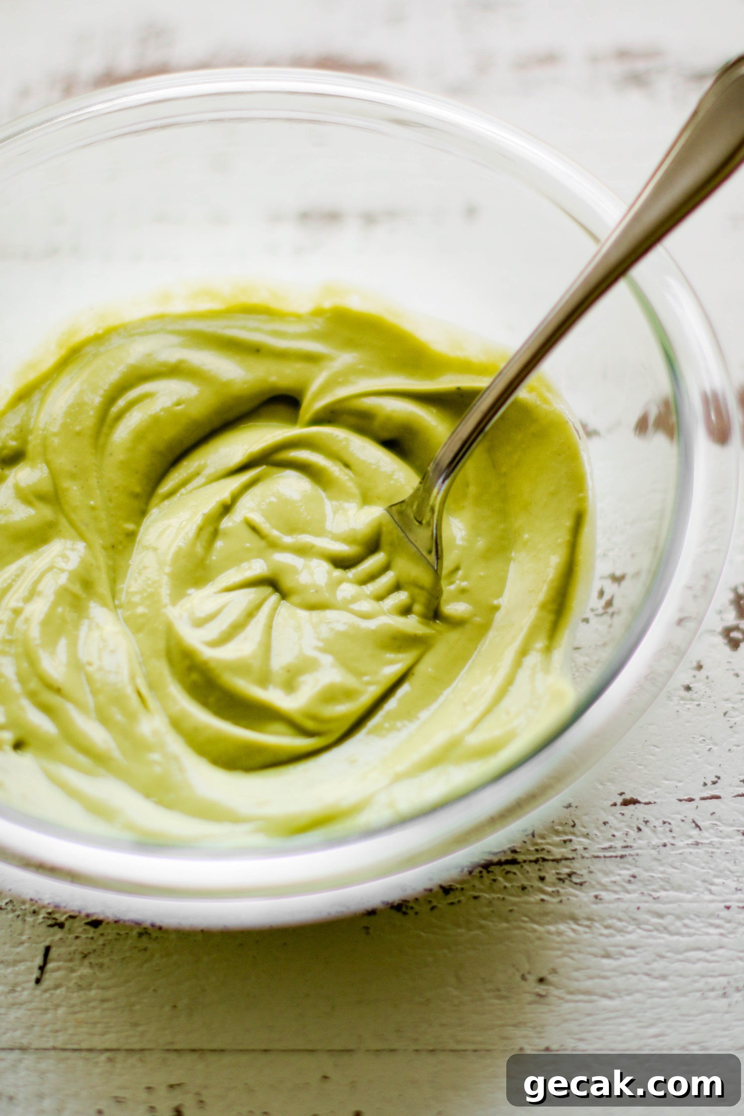 avocado cream dressing mixed in glass bowl with a fork by Flora & Vino 