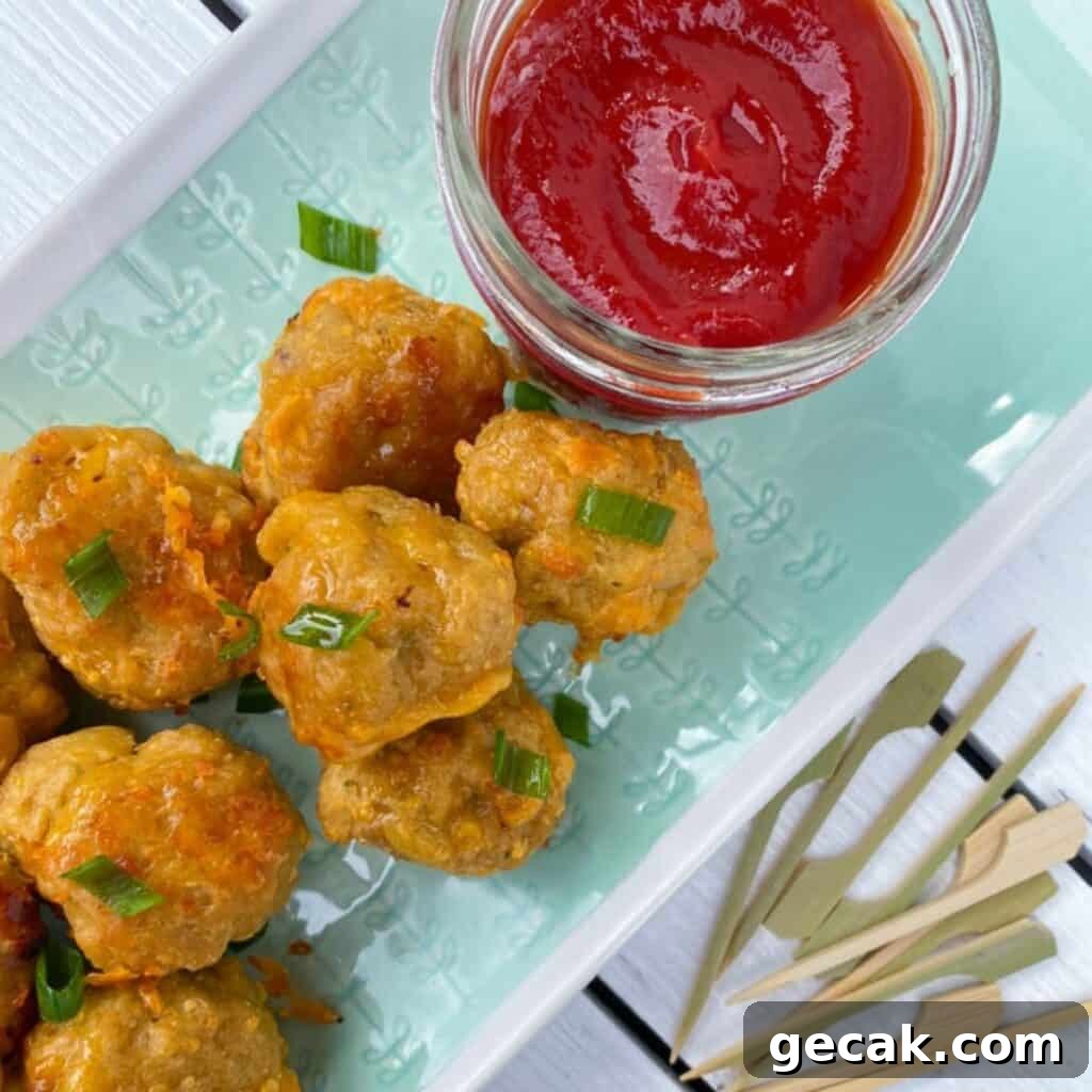 sausage balls without pancake mix on a plate with ketchup and skewers.