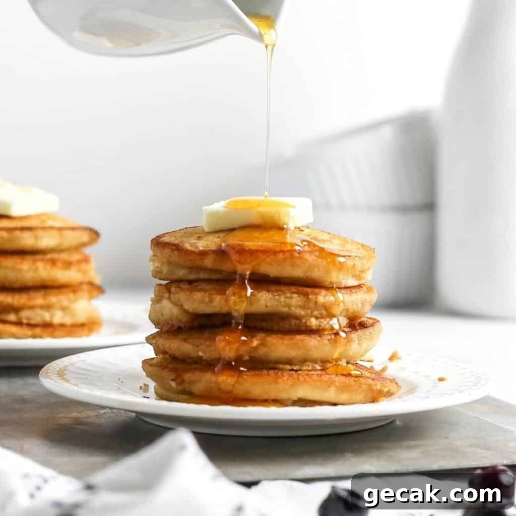 Silver dollar pancakes on a plate stacked with a skewer.