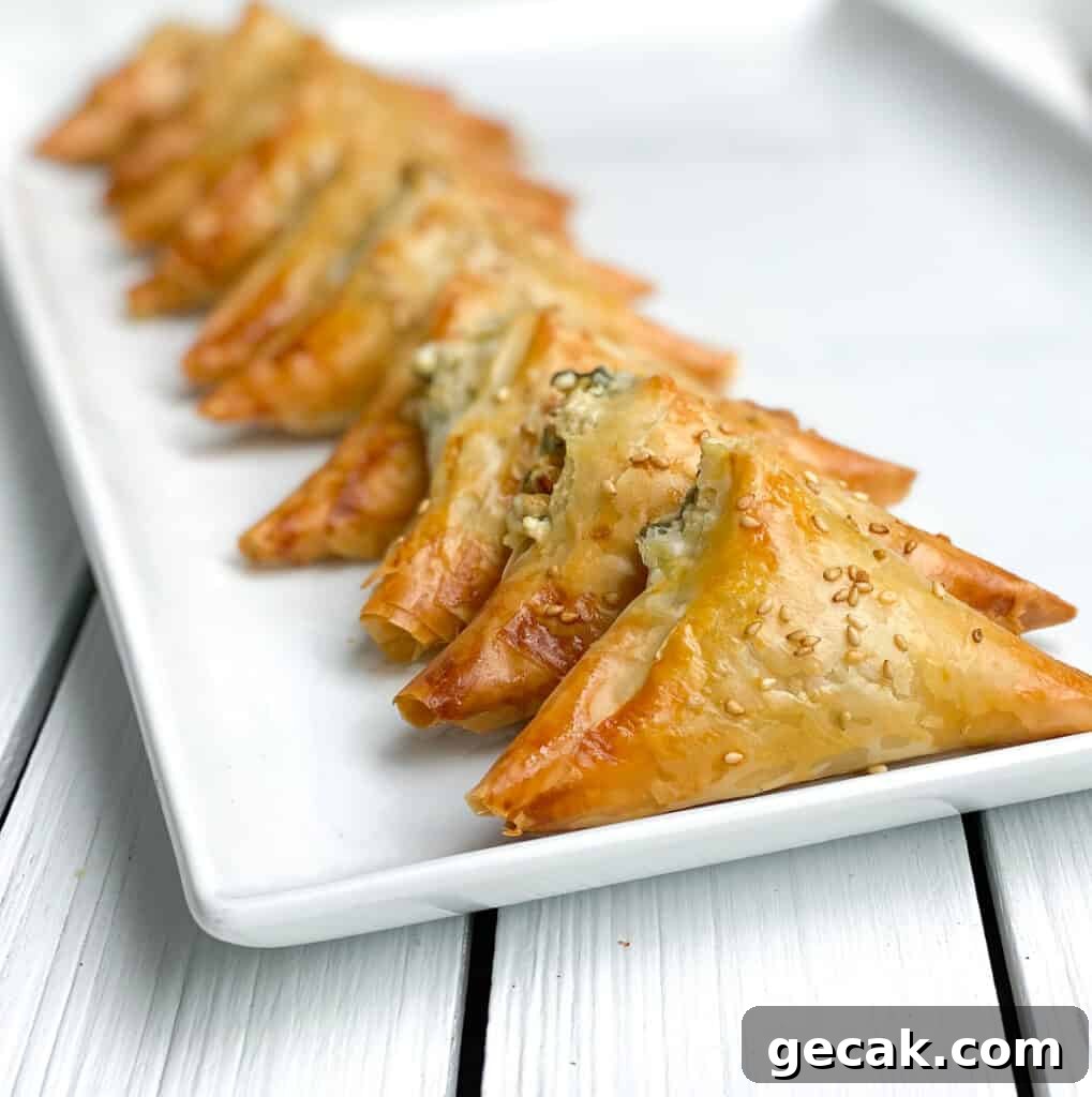 spinach and feta phyllo triangles on a white plate