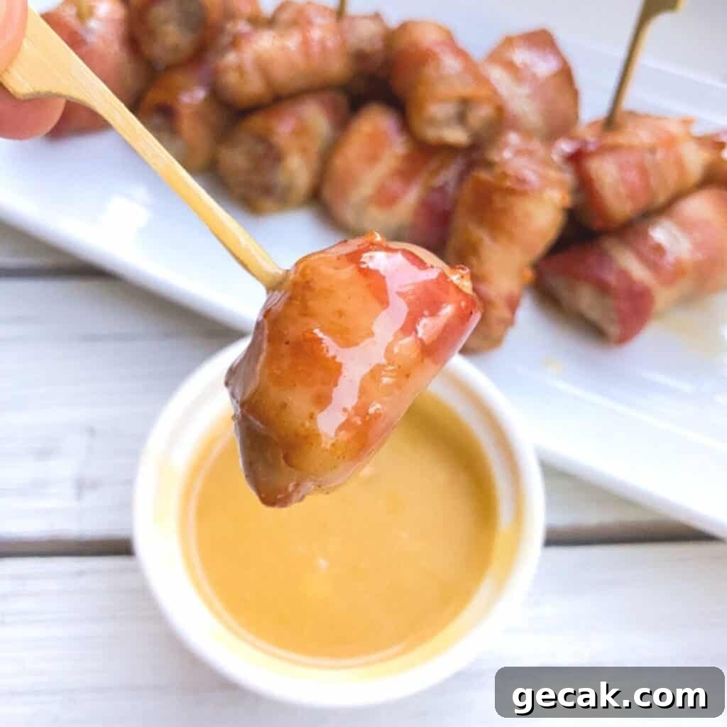 Pork cubes wrapped in bacon served on a skewer.